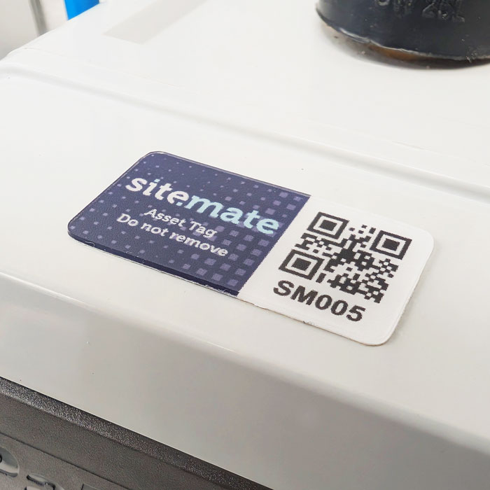 Asset tag on white equipment: purple label reading 'sitemate Asset Tag Do not remove' next to a QR code labeled SM005.