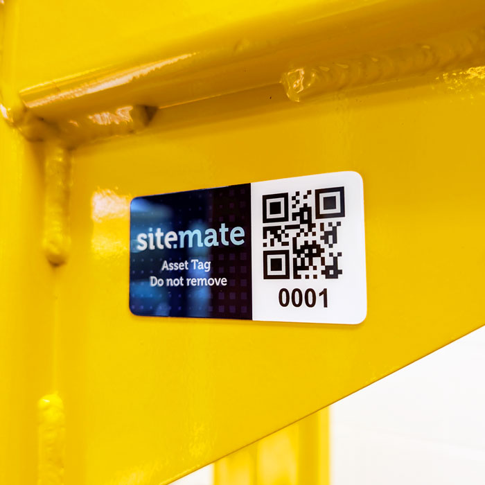 Asset tag with QR code and number 0001 on a yellow metal beam; reads 'sitemate Asset Tag Do not remove'
